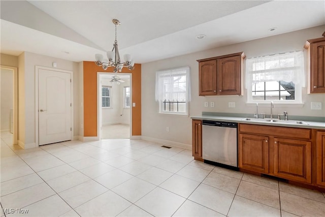 kitchen with sink, stainless steel dishwasher, vaulted ceiling, light tile patterned flooring, and ceiling fan with notable chandelier