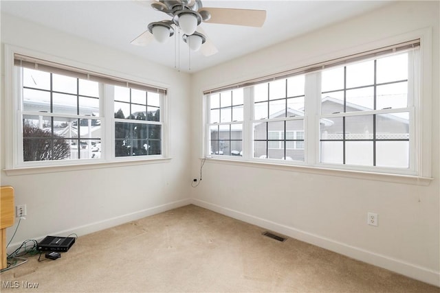 carpeted spare room with ceiling fan