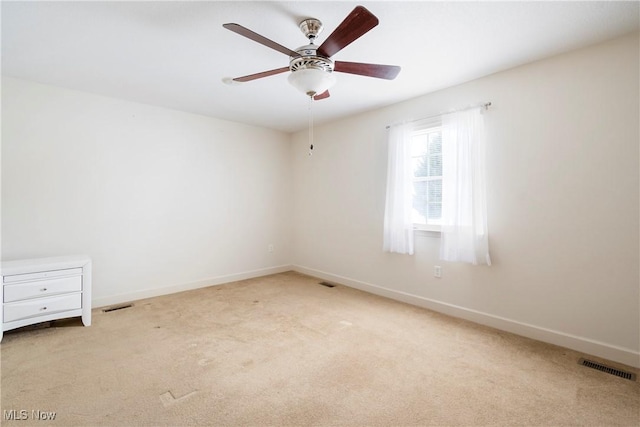 spare room featuring ceiling fan and light colored carpet