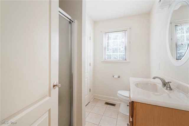 bathroom with tile patterned floors, a shower with door, vanity, and toilet