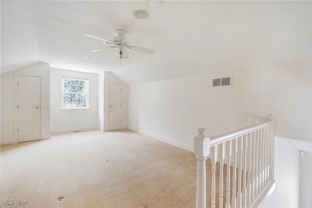 additional living space featuring ceiling fan, light carpet, and vaulted ceiling