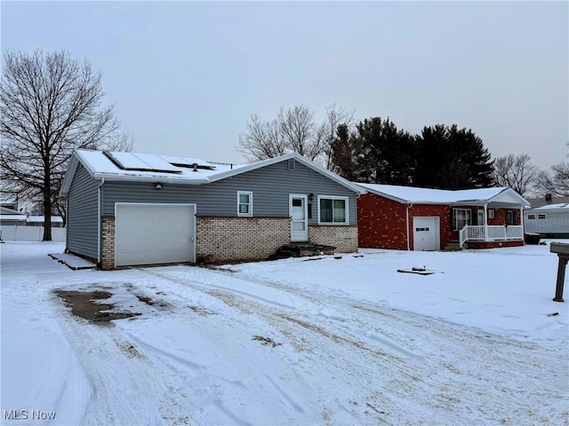 single story home with solar panels and a garage