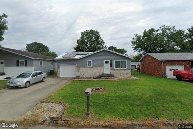 single story home with a front yard, solar panels, and a garage