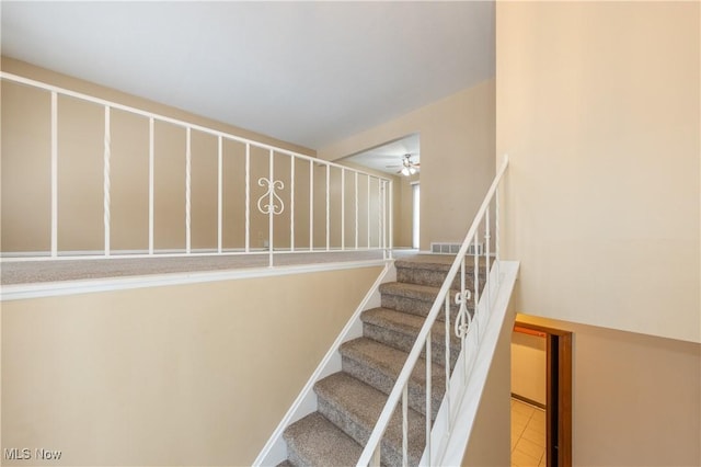 stairs featuring tile patterned floors and ceiling fan