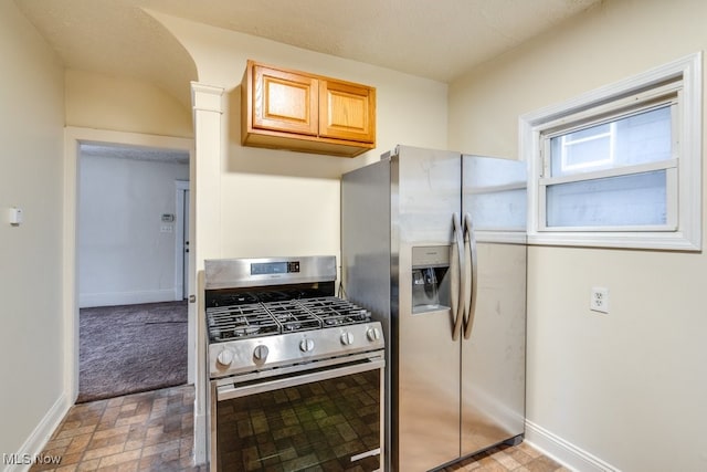 kitchen with decorative columns, light brown cabinets, and stainless steel appliances