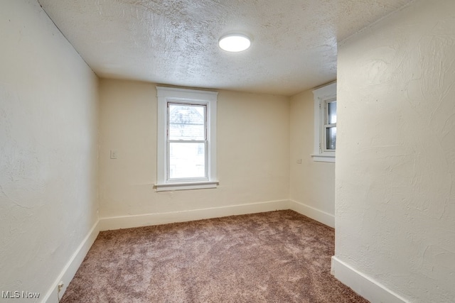 empty room with carpet and a textured ceiling