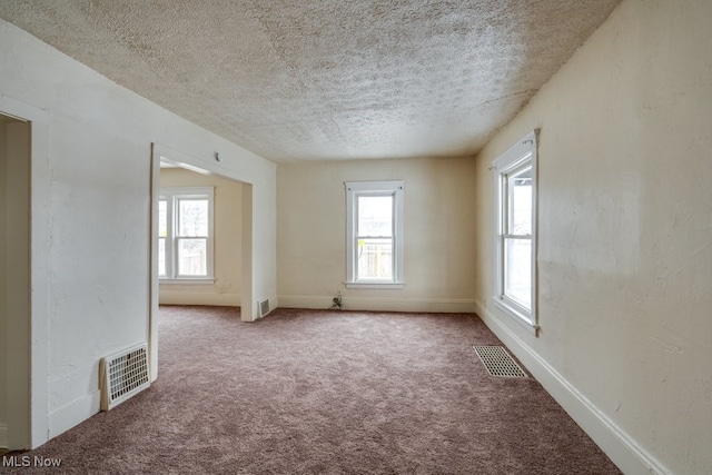 empty room featuring carpet flooring and a textured ceiling