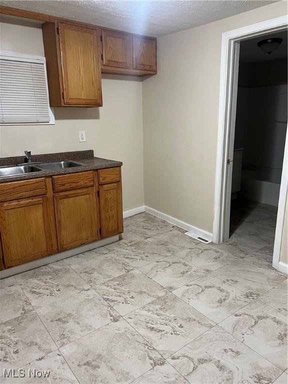 kitchen with sink and a textured ceiling