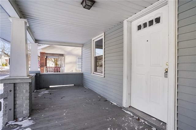 view of exterior entry featuring covered porch