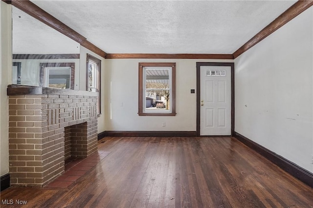 unfurnished living room with a textured ceiling, a brick fireplace, and dark wood-type flooring