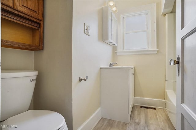 bathroom with hardwood / wood-style flooring, vanity, and toilet