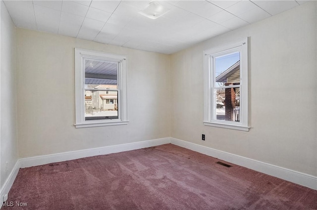 carpeted spare room featuring plenty of natural light