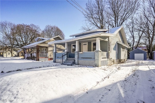 view of front of home featuring an outbuilding, a porch, and a garage