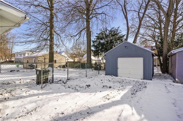 yard covered in snow with a garage and an outbuilding