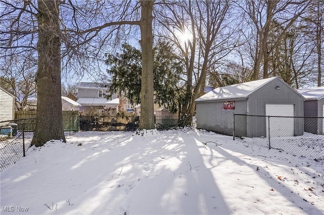 yard covered in snow with an outbuilding and a garage