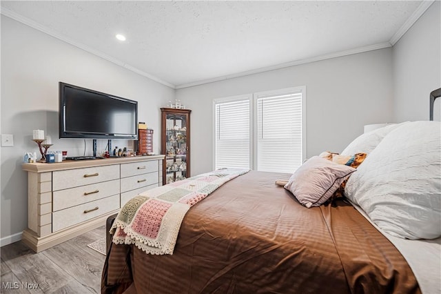 bedroom with hardwood / wood-style floors and crown molding