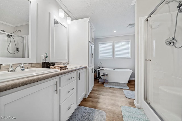 bathroom featuring wood-type flooring, a textured ceiling, and ornamental molding