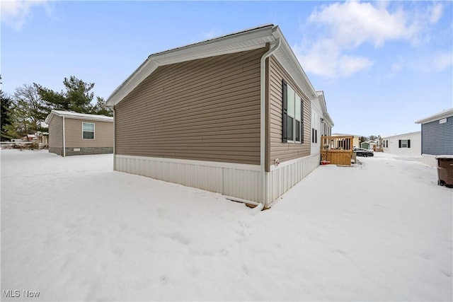 view of snowy exterior with a deck