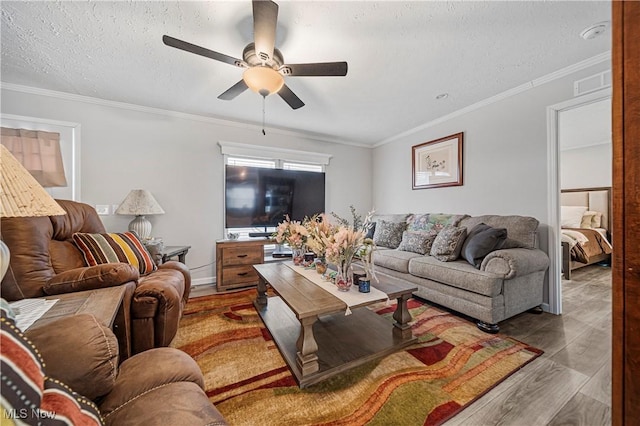 living room featuring ceiling fan, hardwood / wood-style floors, and ornamental molding