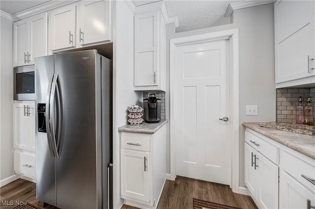 kitchen with dark wood-type flooring, white cabinets, a textured ceiling, tasteful backsplash, and stainless steel appliances