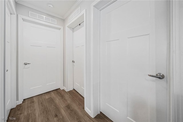 corridor featuring dark hardwood / wood-style flooring and crown molding