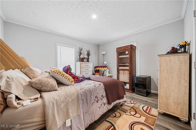 bedroom featuring crown molding, a textured ceiling, and light hardwood / wood-style flooring