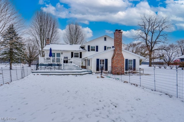 snow covered property featuring a wooden deck