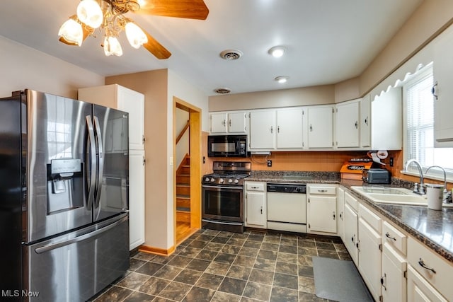 kitchen featuring visible vents, a sink, appliances with stainless steel finishes, white cabinetry, and dark countertops