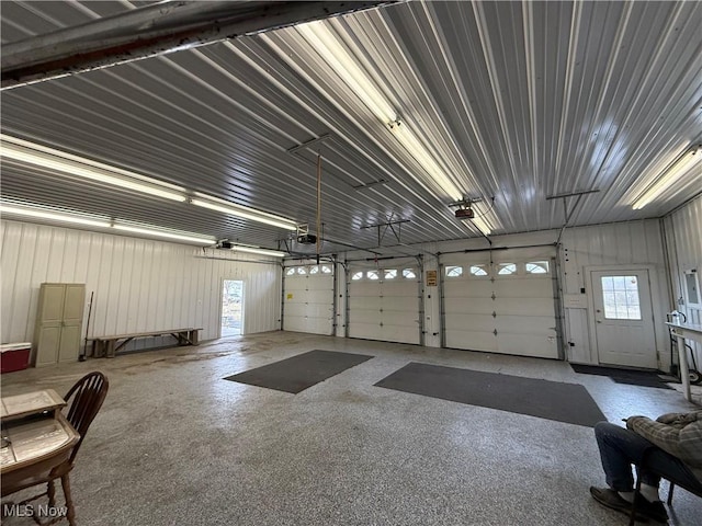 garage featuring metal wall and a garage door opener