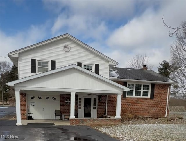 view of front of home with a ceiling fan, a porch, a garage, aphalt driveway, and brick siding