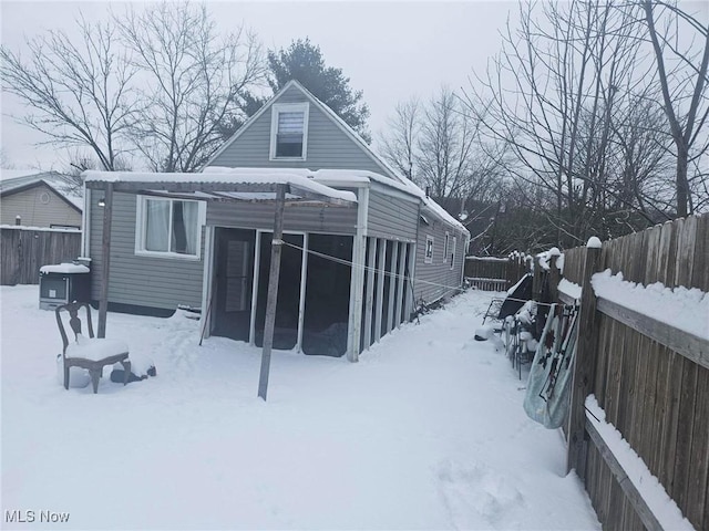 view of snow covered back of property