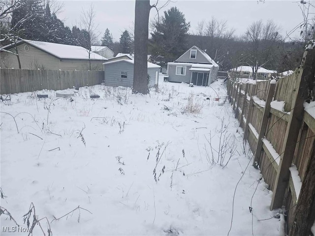 yard covered in snow with an outbuilding