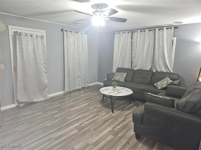 living room featuring hardwood / wood-style floors, ceiling fan, and a textured ceiling