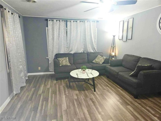 living room with ceiling fan and dark wood-type flooring