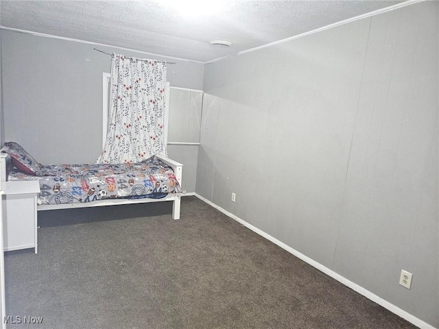 unfurnished bedroom with dark carpet and a textured ceiling