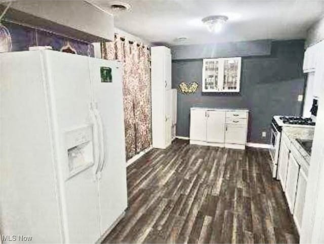 kitchen featuring white cabinets, dark hardwood / wood-style flooring, stove, and white fridge with ice dispenser