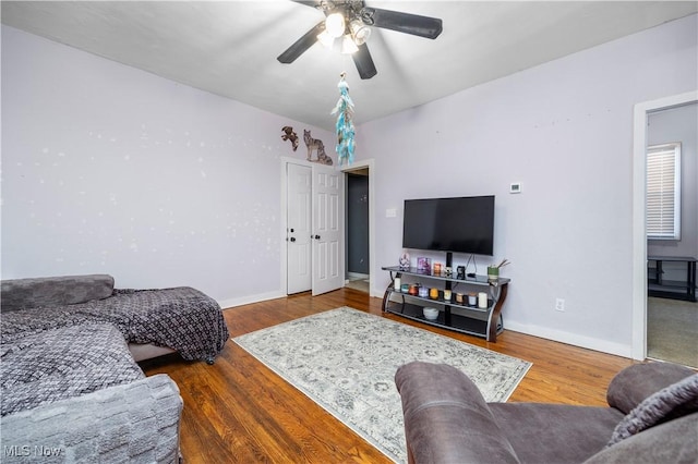 living room featuring hardwood / wood-style floors and ceiling fan