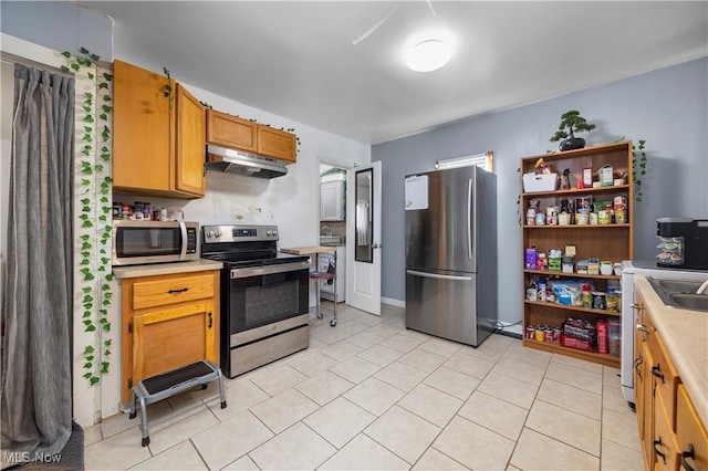 kitchen featuring light tile patterned flooring, appliances with stainless steel finishes, and sink