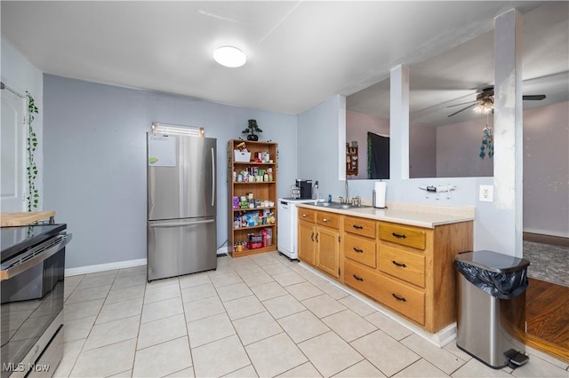 kitchen with sink, stainless steel appliances, ceiling fan, and light tile patterned flooring