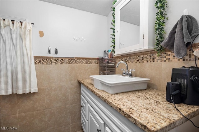 bathroom with vanity and tile walls