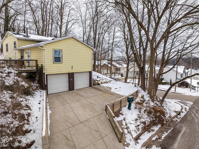 view of snow covered exterior featuring a wooden deck and a garage