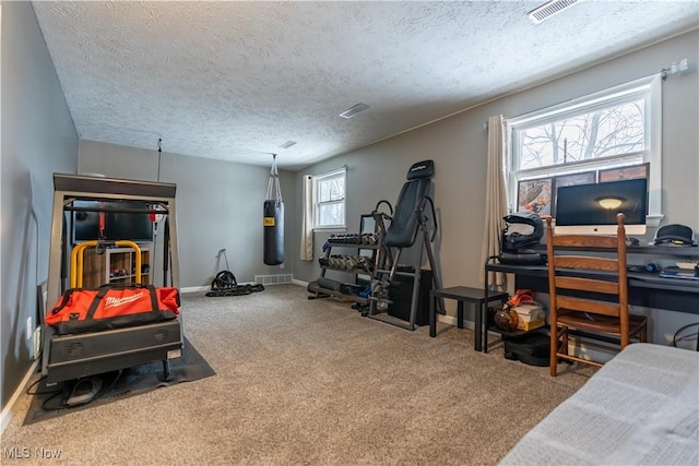 exercise area with carpet and a textured ceiling