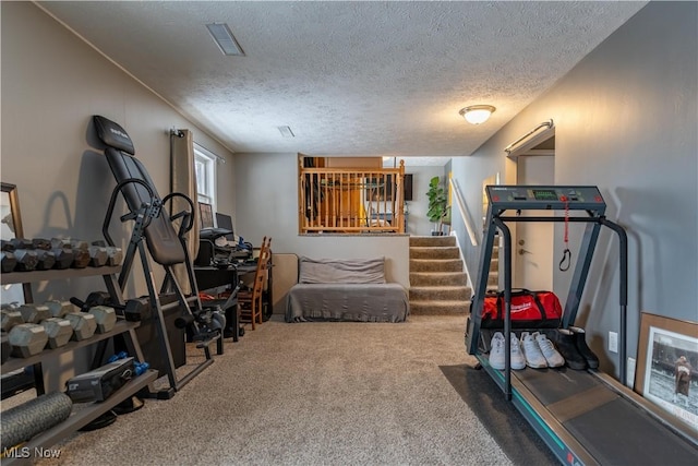 workout area with carpet flooring and a textured ceiling