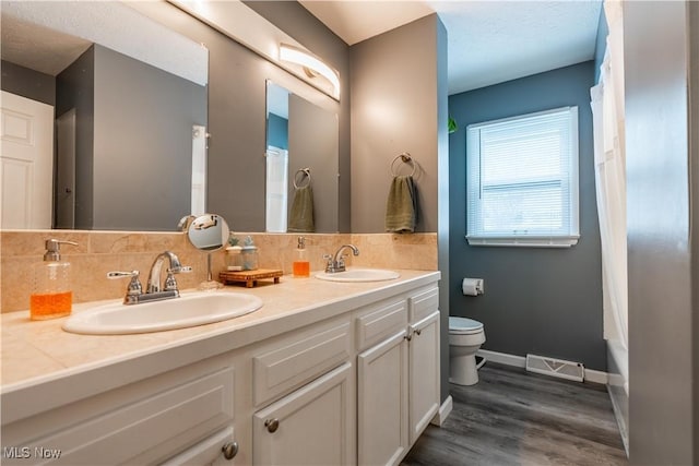 bathroom with hardwood / wood-style floors, vanity, and toilet