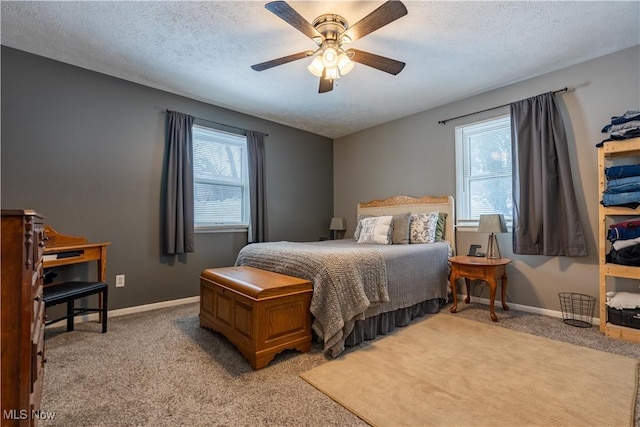 bedroom featuring multiple windows, ceiling fan, light carpet, and a textured ceiling