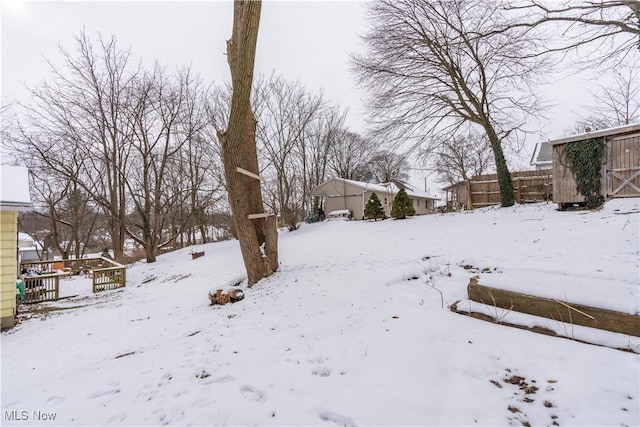 yard layered in snow with a shed