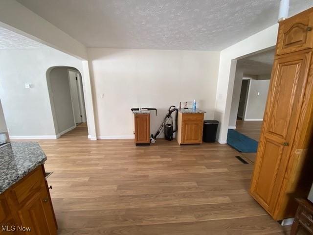 interior space with a textured ceiling and light hardwood / wood-style flooring