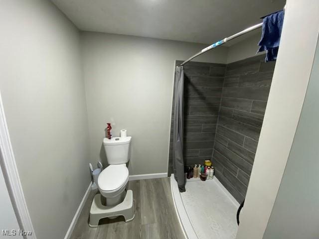 bathroom featuring toilet, wood-type flooring, and a shower with shower curtain