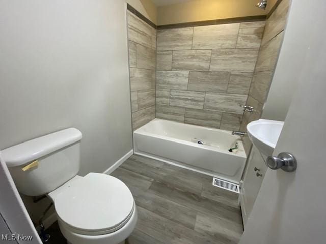 full bathroom with toilet, vanity, tiled shower / bath combo, and hardwood / wood-style flooring