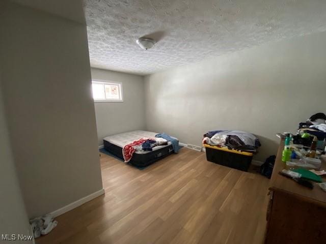 unfurnished bedroom featuring a textured ceiling and wood-type flooring